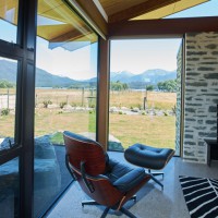 Eames chair by fireplace with view out the window
