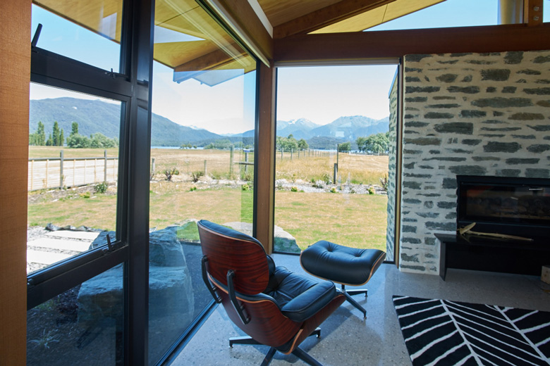 Eames chair by fireplace with view out the window