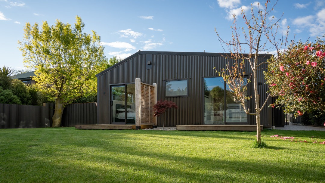 Side view of a house alteration, showing the transformation of an old bach into an updated home.