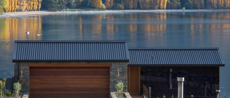 View from the road overlooking the rear of the house with expansive views toward the lake and surrounding landscape.