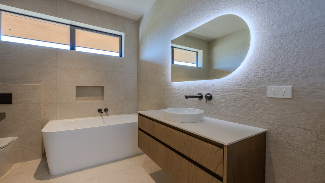 Elegant bathroom featuring warm, tactile materials, soft lighting, and a sleek modern design with a calming, spa-like atmosphere.