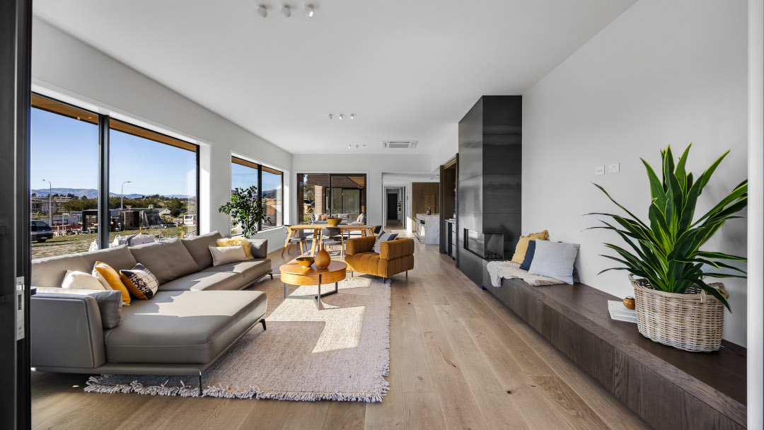 Looking across the open-plan living area, bespoke kitchen, and furniture in a contemporary interior space.