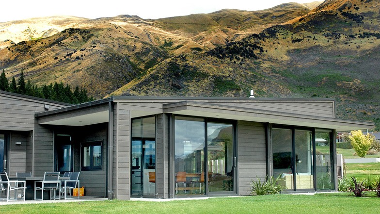 Side view looking into the open-plan lounge, kitchen, and dining area, with views extending out to an outdoor courtyard.