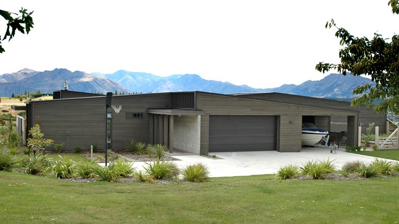 Entry and garage view of house, showcasing exterior cladding of horizontal cedar weatherboards and board-formed tilt-slab concrete.