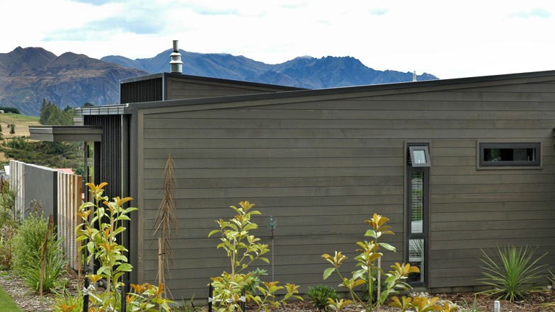 View of external cladding featuring grey-stained horizontal cedar weatherboards.