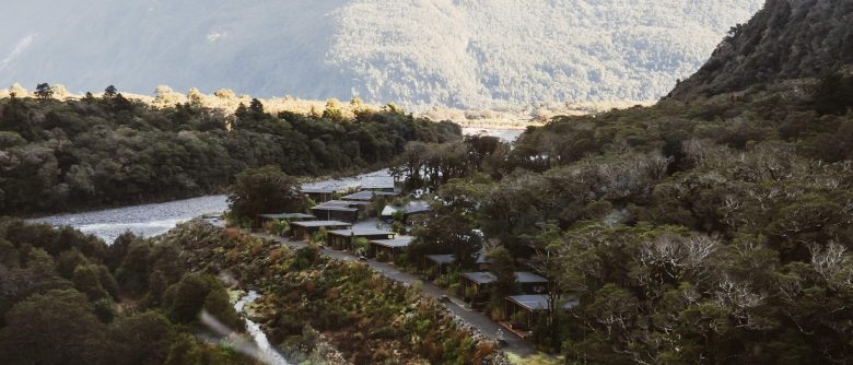 Aerial view of Milford Sound Lodge in winter, surrounded by, native bush, and dramatic mountain scenery.