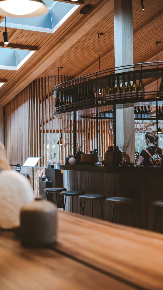 Milford Sound Lodge restaurant and bar interior with skylights overhead, looking up through the ceiling and roof structure to the sky above.