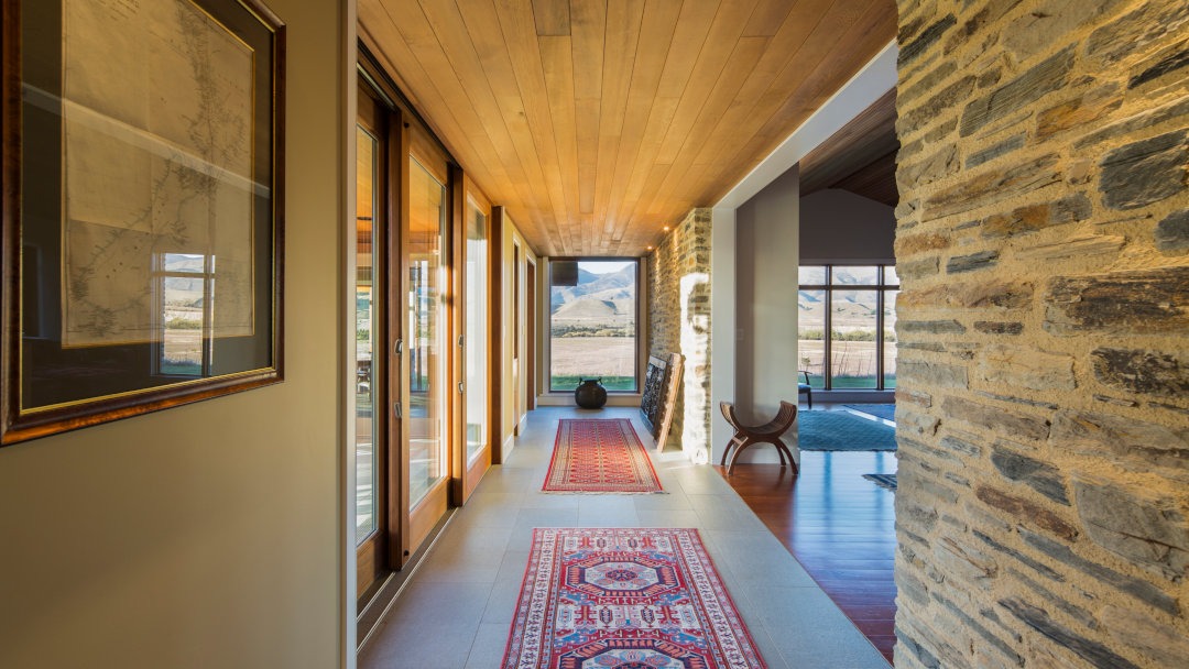 View down the hallway, with doors to the courtyard on the left and the entrance to the living, dining and kitchen areas on the right.